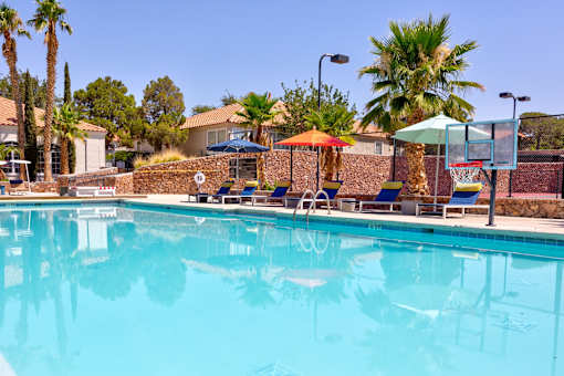 a swimming pool with chairs and umbrellas at a resort