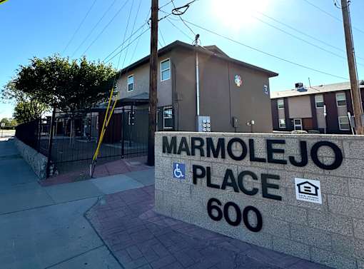The image shows a building with a sign that reads "MARMOLEJO PLACE 600".