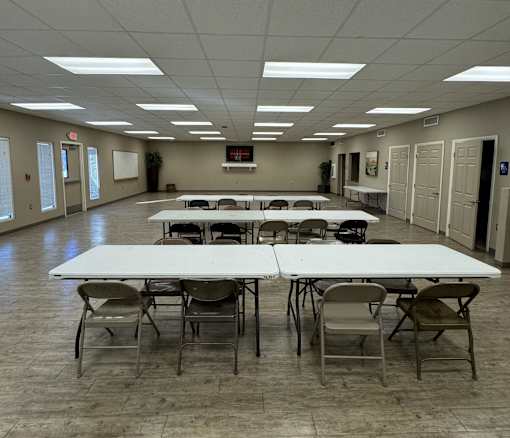 A large room with tables and chairs is empty.