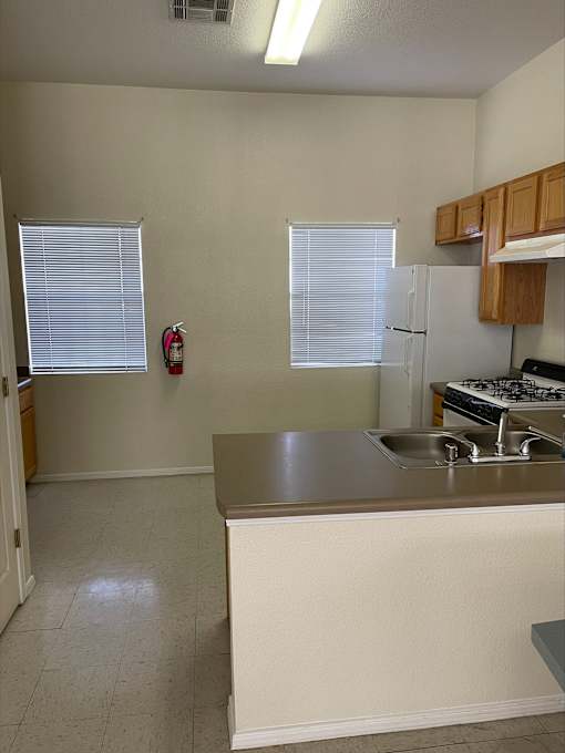 A kitchen with a white refrigerator and a stove top oven.