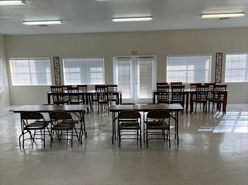 A room with tables and chairs and an exit sign.