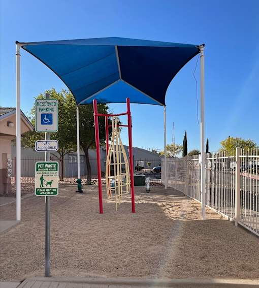 A playground with a blue canopy and a sign that says "Reserved Parking".
