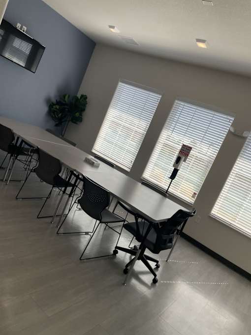 A conference room with a long table and chairs.