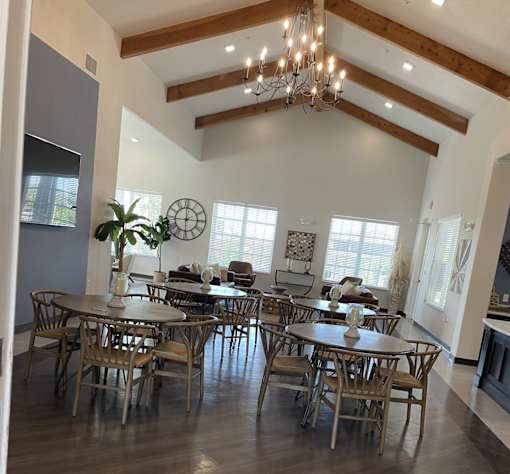 A dining room with a large table and chairs.
