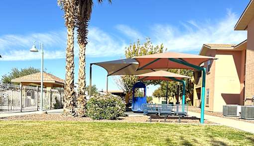 A playground with a blue slide and a red canopy.
