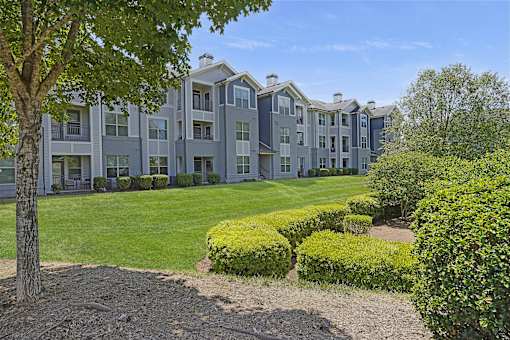 A large building with a green lawn in front.