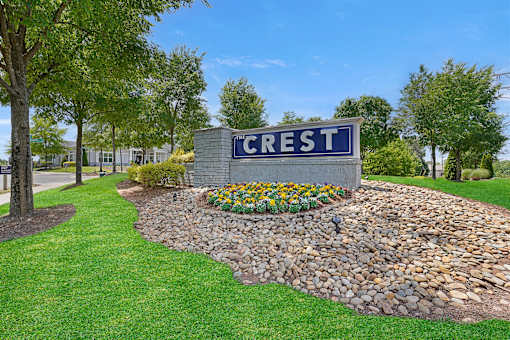 A stone wall with a sign that says Crest.