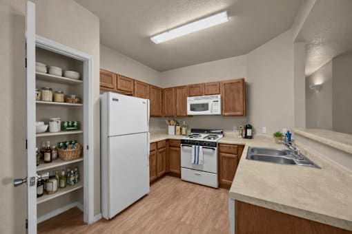 A kitchen with a white refrigerator, wooden cabinets, and a white stove top oven.