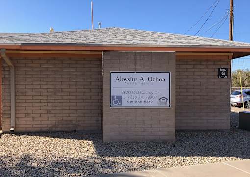 A sign for Aloysius A. Ochoa is displayed in front of a building.