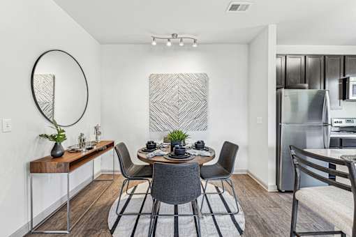 A modern dining room with a wooden table and chairs.