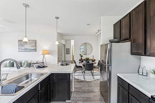 A modern kitchen with a large island and a dining area.