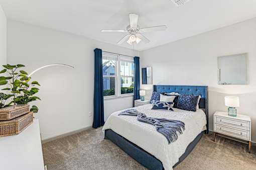 A bedroom with a large bed and a ceiling fan.