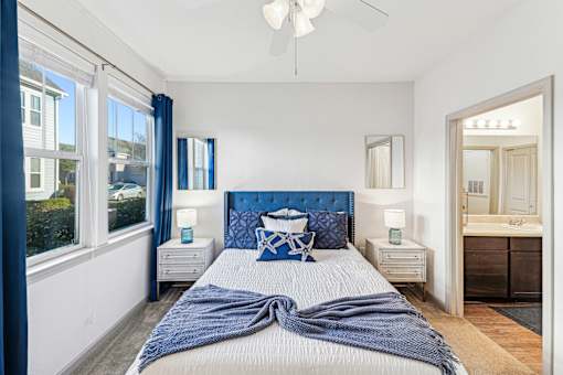 A bedroom with a large bed and a ceiling fan.