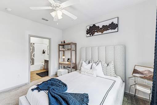 A bedroom with a large bed and a ceiling fan.