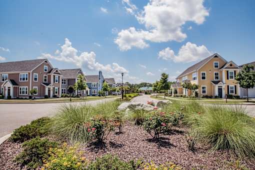 A row of houses with a garden in the foreground.