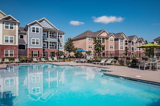 A swimming pool in front of apartment buildings.