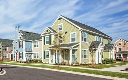 A row of houses with a blue sky in the background.