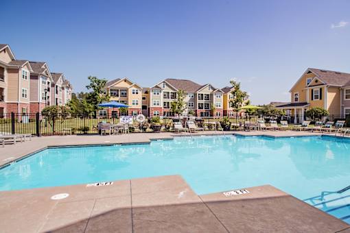 A swimming pool in front of apartment buildings.