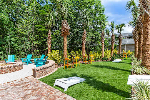 A backyard with a white table surrounded by palm trees.