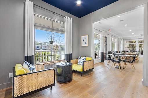 A living room with a yellow sofa and a black coffee table.