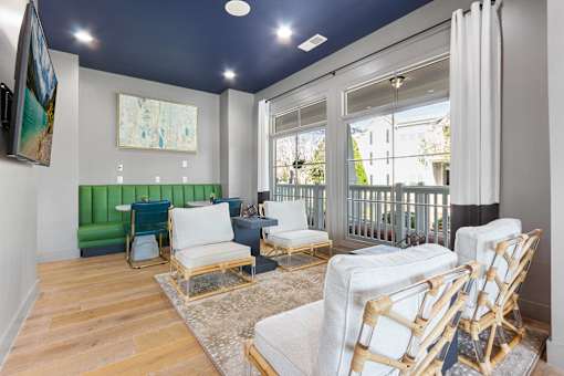 A living room with white furniture and a green couch.
