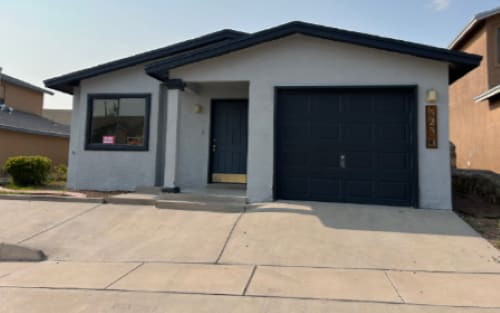 A two-story house with a garage door and a window.