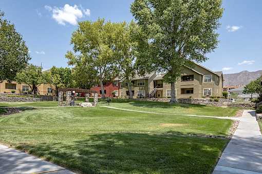 A row of houses with a green lawn in front.