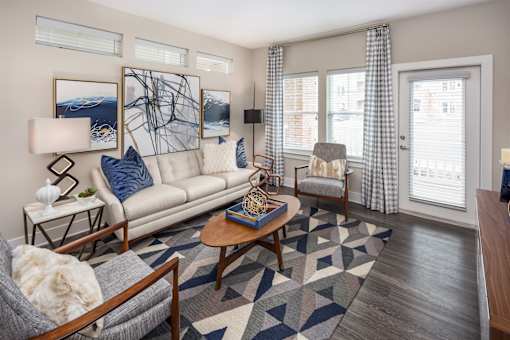 A living room with a grey couch, a coffee table, and a chair.