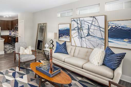 A living room with a couch, a coffee table, and a large painting on the wall.