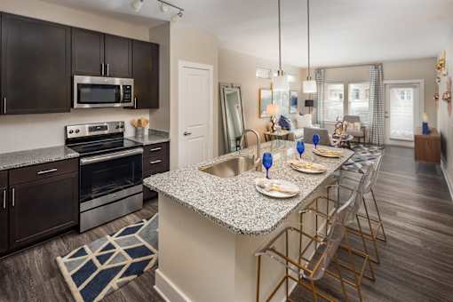 An open-concept floor plan with a kitchen island and stainless steel appliances.