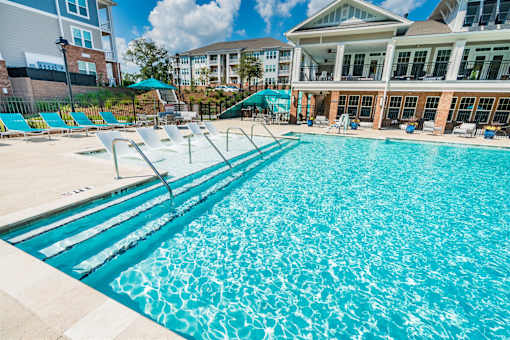 A large swimming pool with a building in the background.