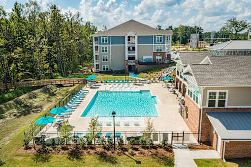 A large swimming pool surrounded by a fence and trees.