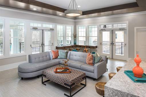 The clubroom lounge with a grey couch and a coffee table.