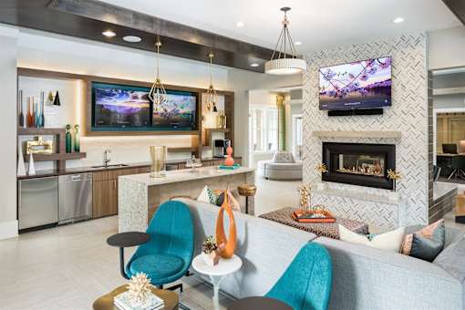 A clubroom with fireplace and entertainment with ample seating.