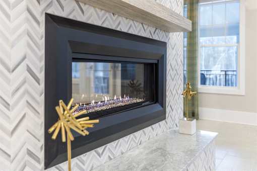 A black fireplace with a gold star decoration in front of it.
