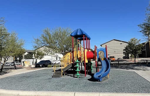 A playground with a blue slide and a red and yellow structure.