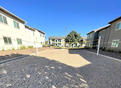 A sunny day at a gravel courtyard surrounded by apartment buildings.