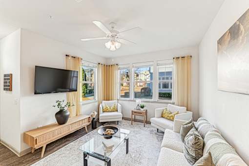 A living room with a flat screen TV mounted on the wall.