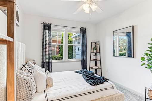 A bedroom with a large bed and a ceiling fan.