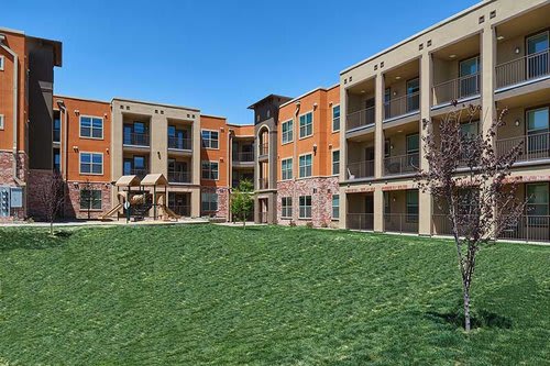 Apartment complex with a green lawn in front.