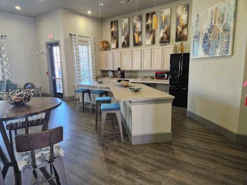 A kitchen with a table and chairs in front of a counter.