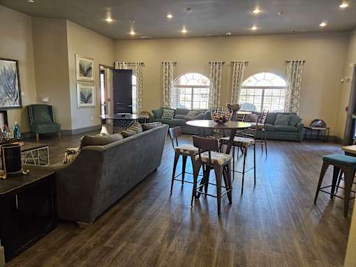 A living room with a grey couch and wooden floors.