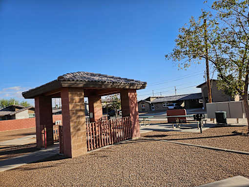 A gazebo-like structure sits in the middle of a playground.
