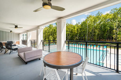 A patio with a table, chairs, and a pool.