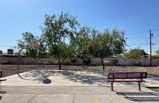 A basketball court with a red bench and a basketball hoop.