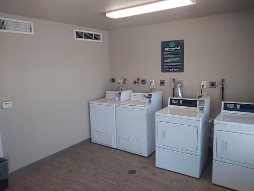 A laundromat with washers and dryers in it.