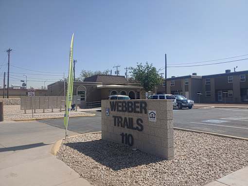 A sign for Weber Trails 110 is in front of a building.