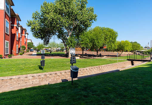 A grassy area with a mailbox and a tree in the foreground.