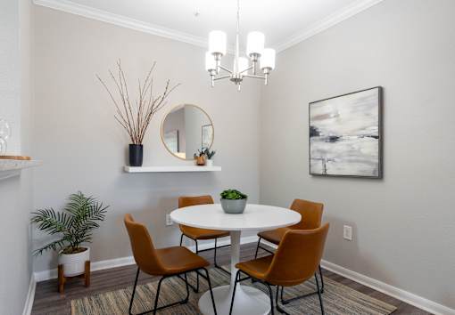 A dining room with a white table and chairs.