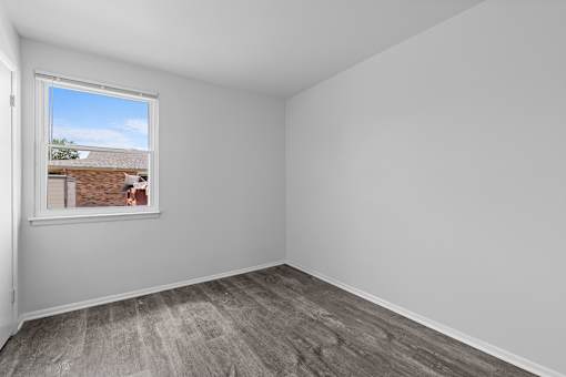 A room with a window showing a view of a building outside.